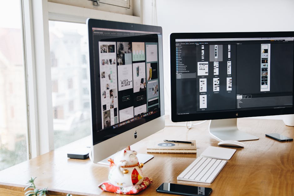 A sleek modern office setup featuring dual monitors, Apple devices, and creative decor in an indoor workspace.